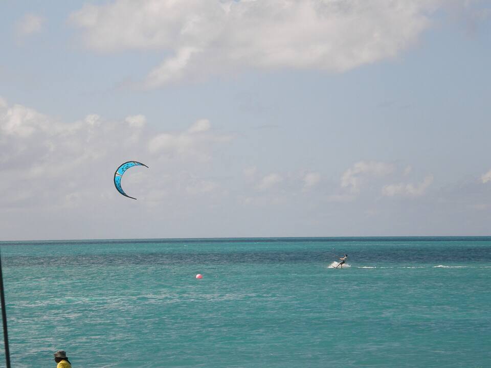 A kiteboarder on the flat turquoise water inside the reef off Anegada