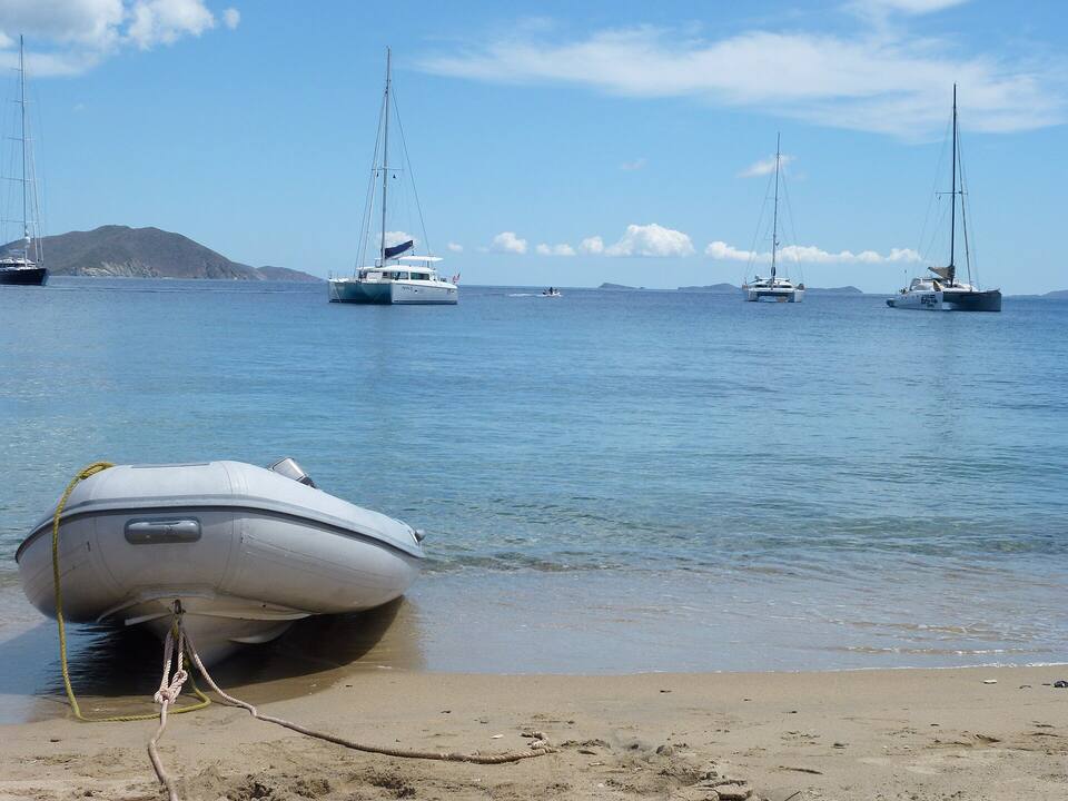 A dinghy pulled up on the beach at Salt Island, Cooper Island's neighbour, with charter catamarans at anchor offshore