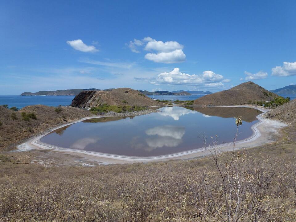 One of Salt Island's salt ponds, ringed with dry scrub, with the Sir Francis Drake Channel beyond