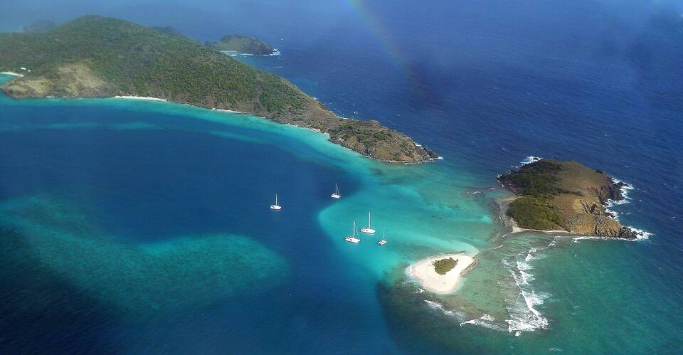 Sandy Spit and Green Cay off Little Jost Van Dyke from the air: a tiny islet of white sand and scrub ringed by reef, Little Jost Van Dyke behind