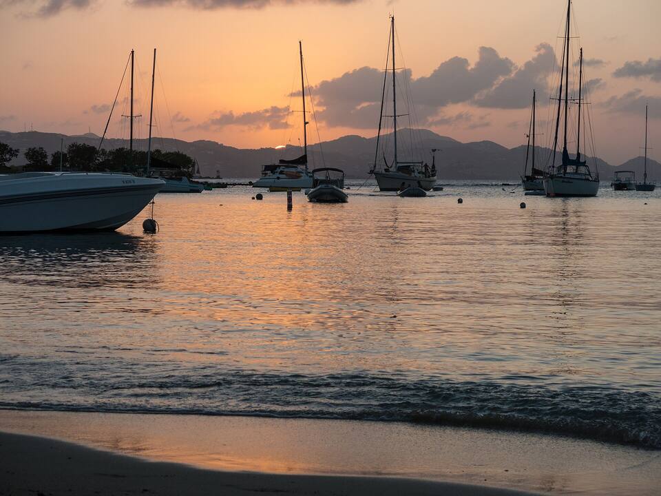 Sailboats on their moorings off Cruz Bay, St. John, at sunset, with St. Thomas across Pillsbury Sound