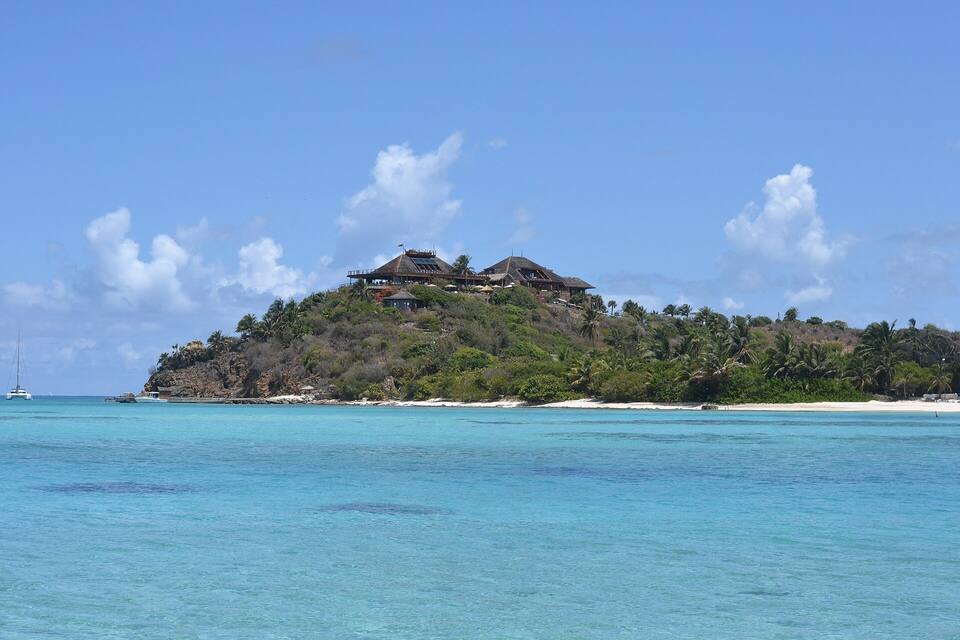 The Great House on its hilltop at Necker Island, seen from the water — the house rebuilt after the 2011 fire