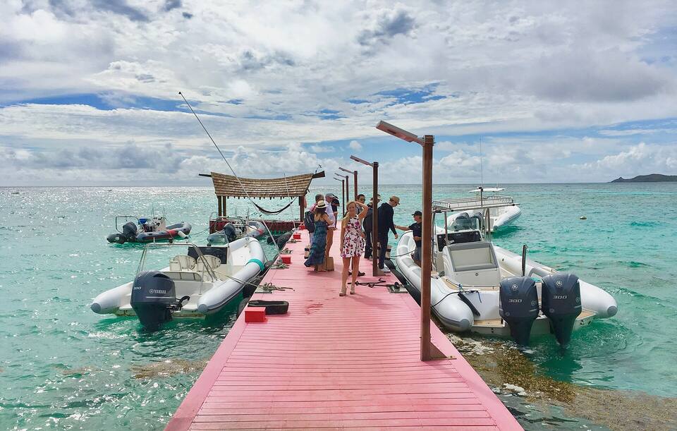 Guests on Necker Island's jetty, with the resort's speedboats tied up either side