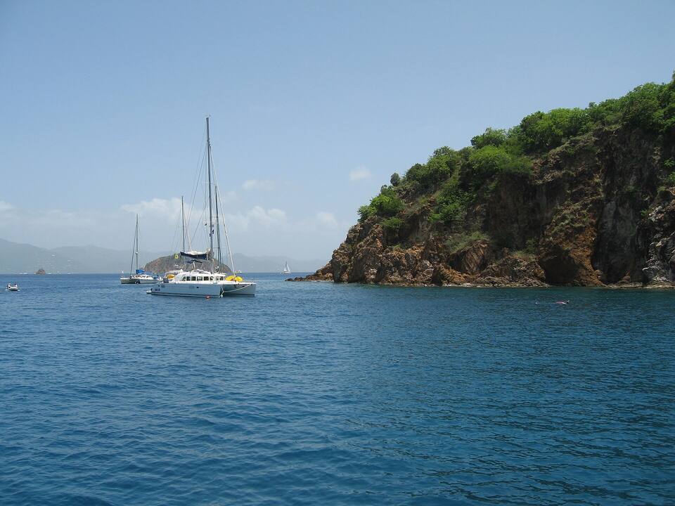 Boats on the day moorings off the cliffs of Treasure Point, where the caves are, with Pelican Island and the Indians beyond and Tortola on the horizon