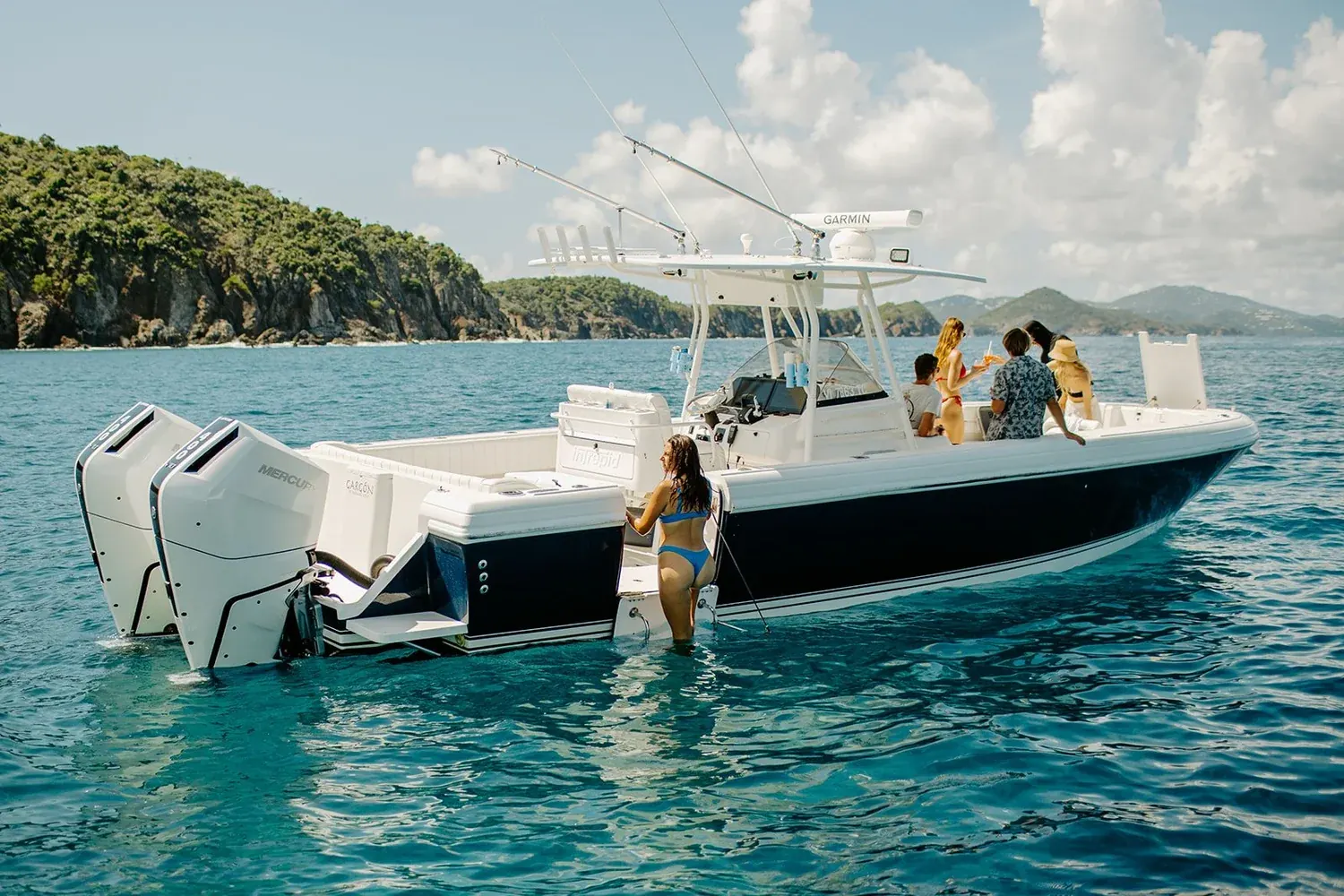 Fun Hog, a 37-foot Intrepid center console, anchored in clear water off a St. John beach with guests aboard